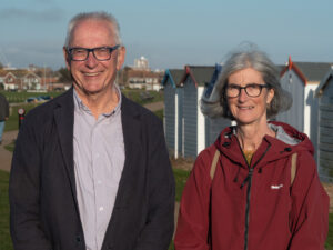 Ian and Claire stand in front of Goring beach huts.
